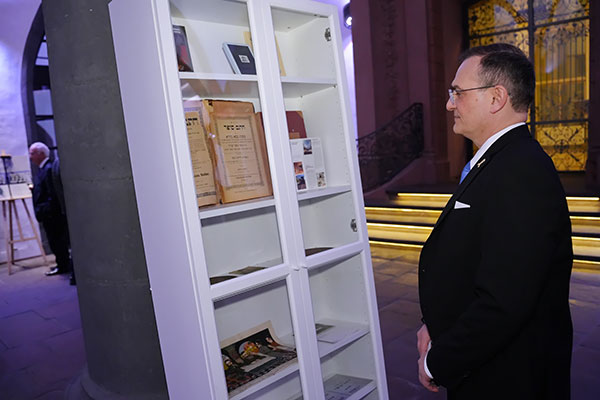 Michael Grauss exploring the rich history and teachings in the old  texts at the Chatam Sofer exhibit.