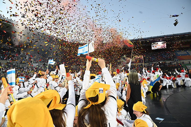 KOL-Jun-25-DE-NEW-confetti MAKKABI Germany athletes at the opening ceremony of the 2022 Maccabiah in Israel celebrate with confetti in the colours of the German flag as their delegation is announced.